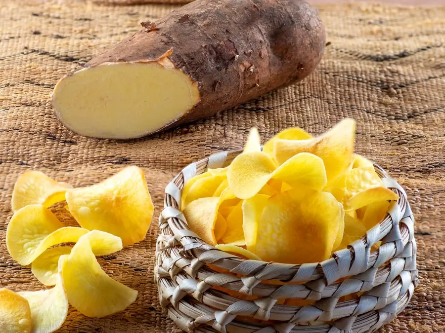 Cut cassava root next to a basket of Frittas cassava chips
