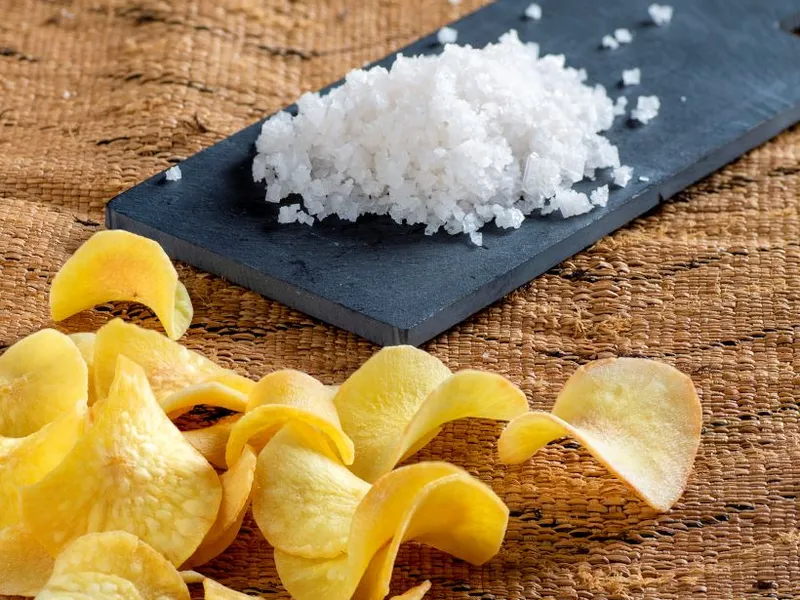 Frittas cassava chips next to a board with sea salt