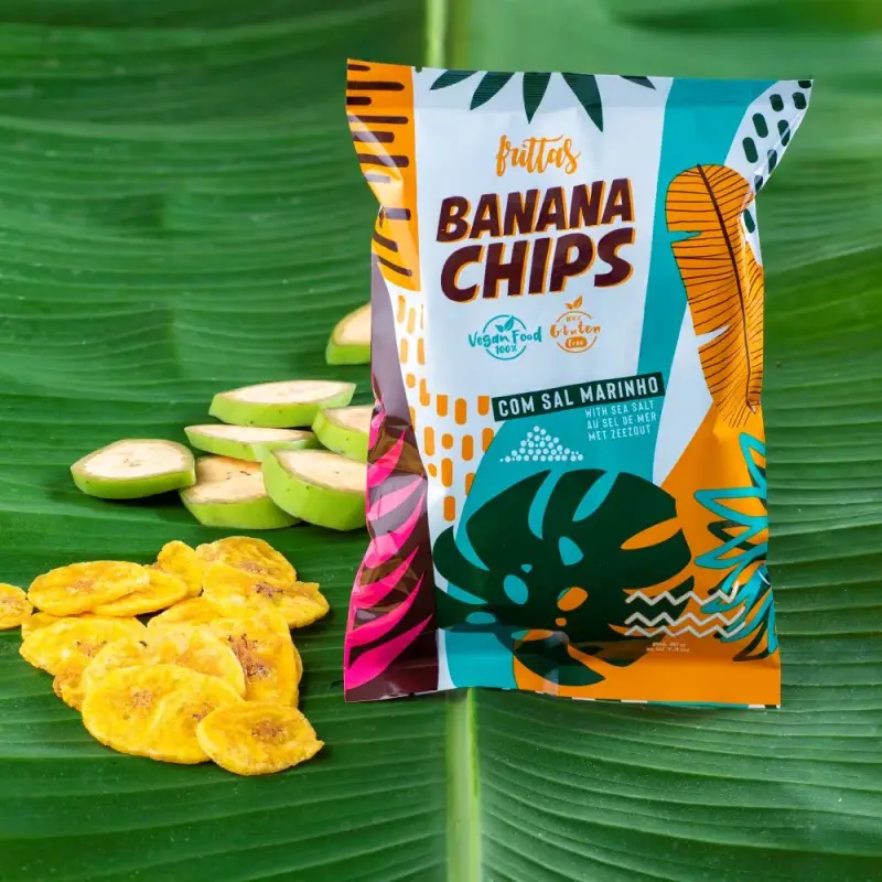 Bag of Frittas plantain chips on a banana leaf, with slices of raw green plantain and chips